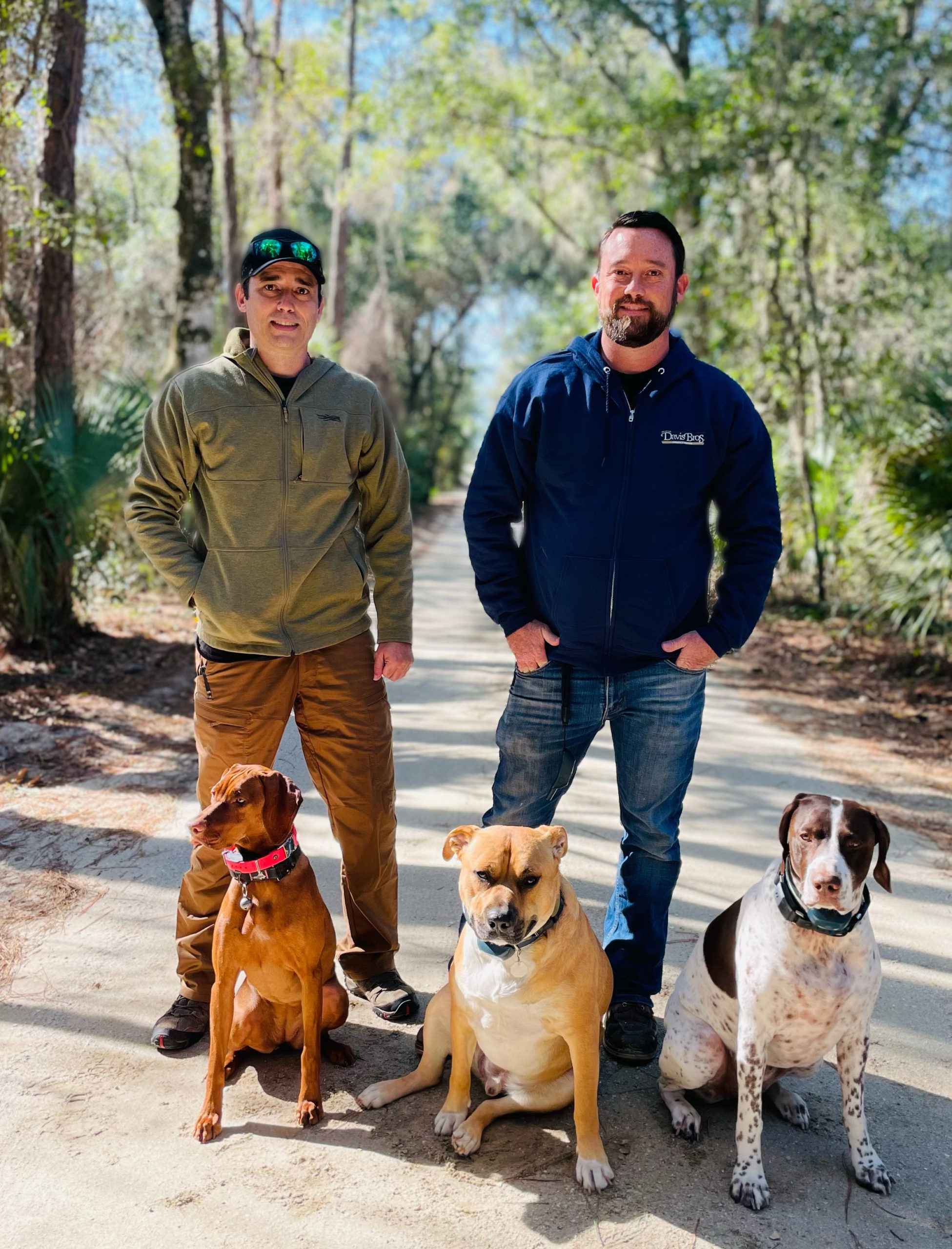 Davis Bros. Owners with their dogs on nature path